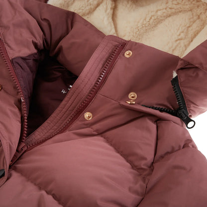 Close-up of a dusty rose puffer jacket showing the quilted fabric, gold snap buttons, a black zipper, and a beige sherpa lining.