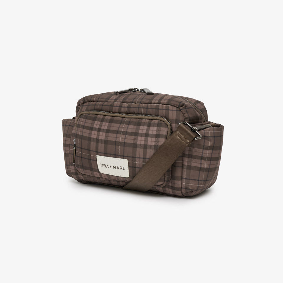 A brown and beige plaid crossbody bag with a brown adjustable strap and a white brand label reading 'Tiba+Marl', shown on a clean white background.