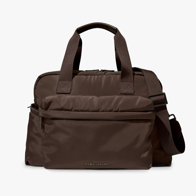 A dark brown nylon duffel bag with top handles, a front zippered pocket, and an adjustable shoulder strap, shown against a plain light gray background.