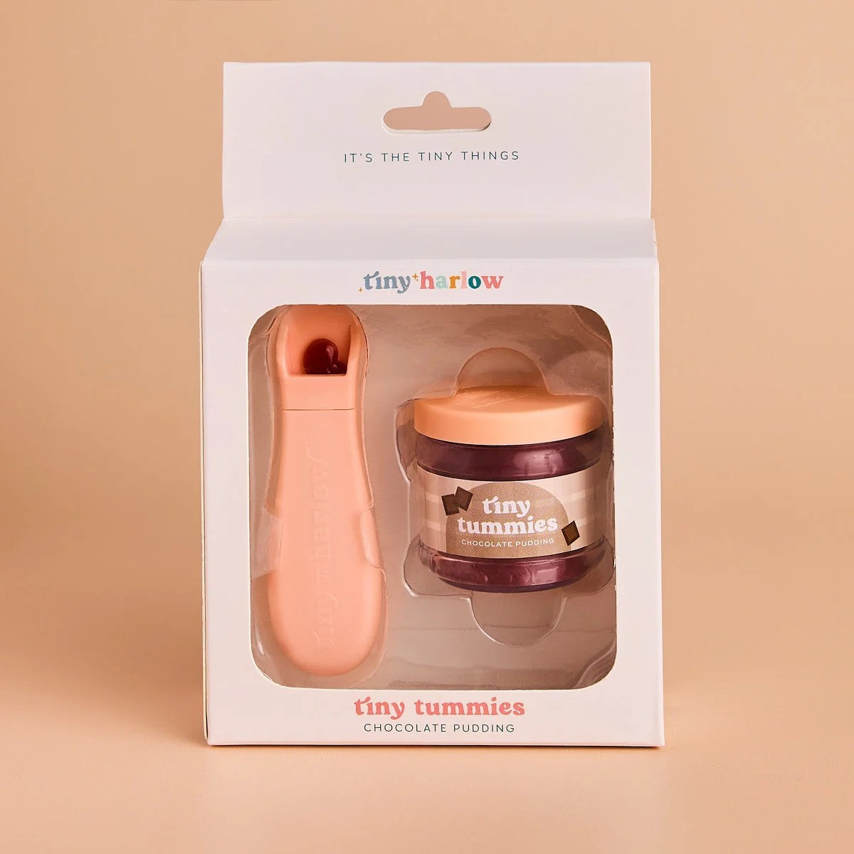Tiny Harrow Chocolate Pudding gift set in its original white packaging, featuring a peach-colored chocolate spoon and a small jar of chocolate pudding with a peach lid, set against a solid beige background.