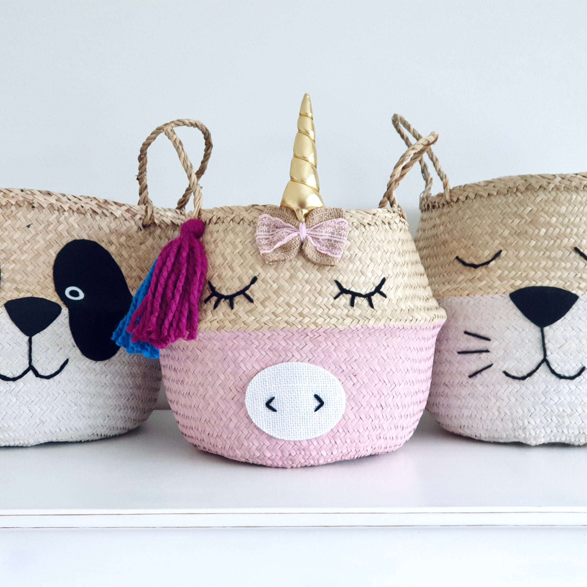 Three decorative baskets shaped like a panda, unicorn, and cat on a white background