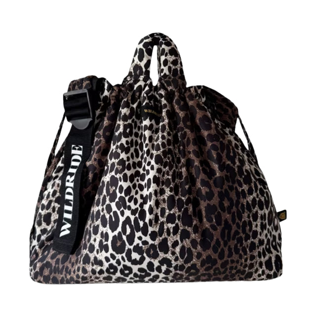 A leopard print drawstring bag with a black adjustable shoulder strap featuring the brand name 'WILDRIDE' in white text, shown against a plain white background.
