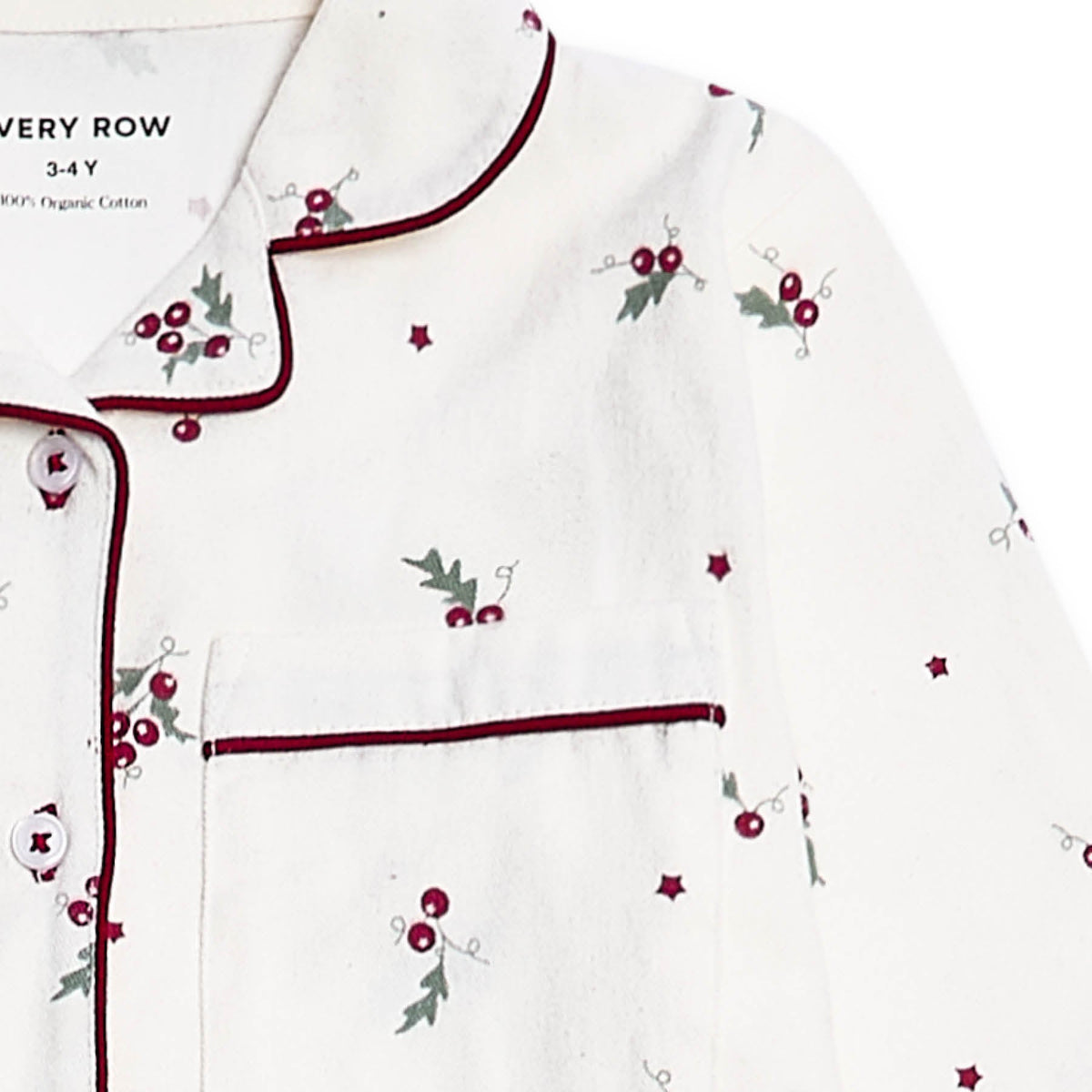 White long-sleeve pyjama top with dark red piping, featuring a chest pocket and an all-over holly and berry print with small star accents.