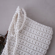 White knitted stocking on a light grey background
