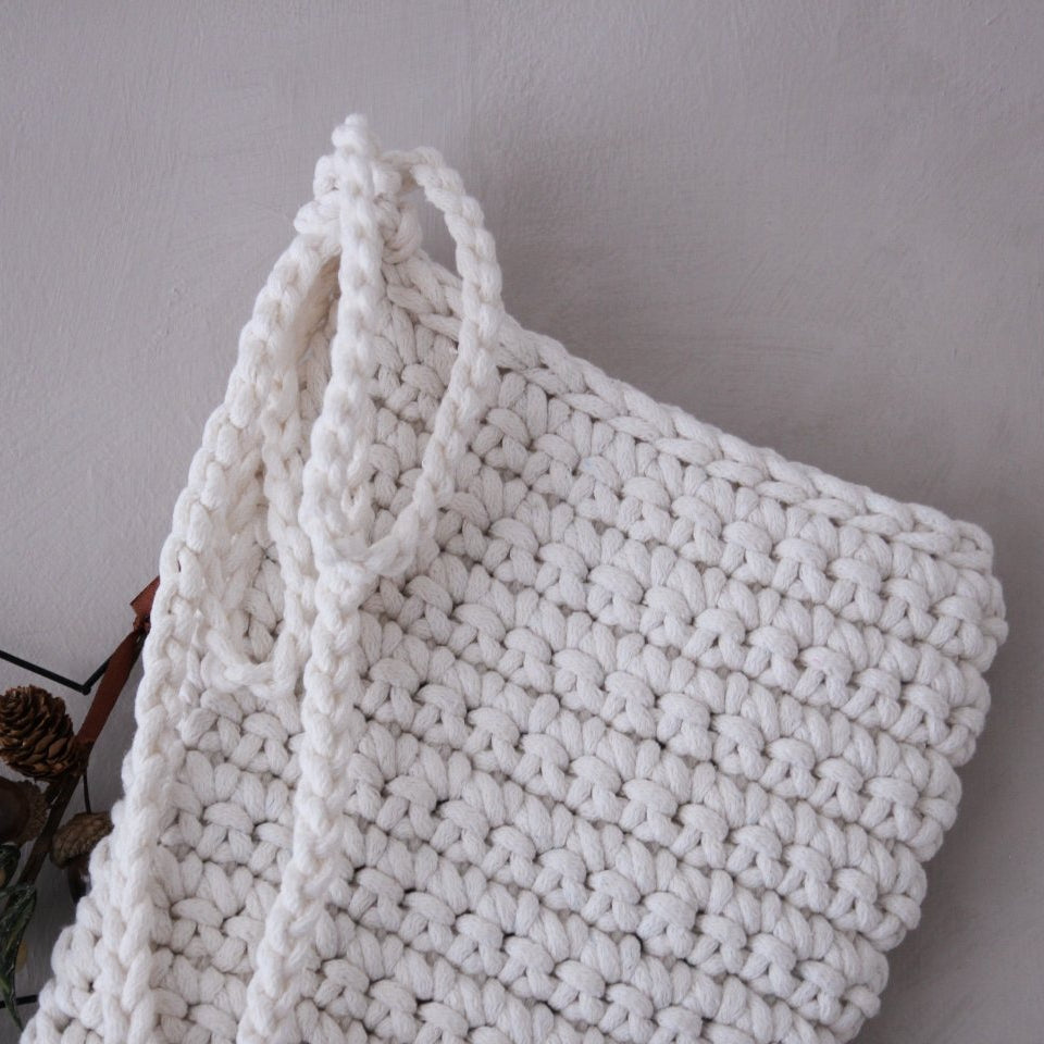 White knitted stocking on a light grey background