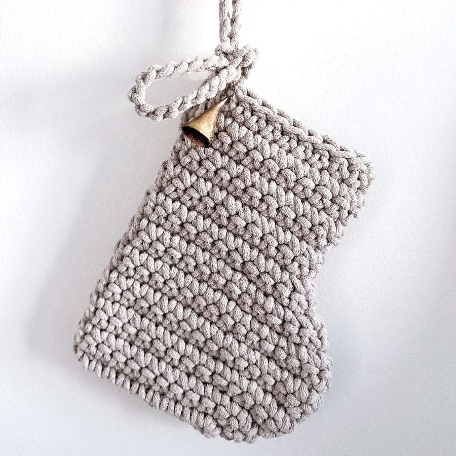 Hanging crocheted oatmeal Christmas stocking on a white background