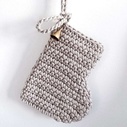 Hanging crocheted oatmeal Christmas stocking on a white background