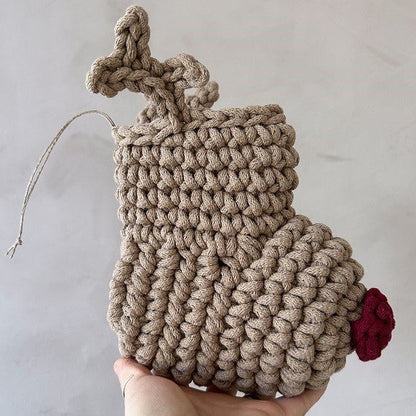 Hand crocheted Christmas stocking with a red nose and antlers on a light gray background
