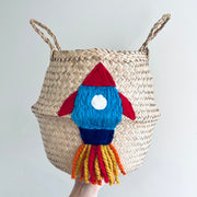 Woven basket with a colourful rocket-shaped decoration on a plain background
