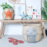 Children's room decor with a wooden shelf, starfish basket, framed pictures, and a jellyfish basket