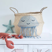 Woven basket with a jellyfish design, starfish, and lobster on a white surface.