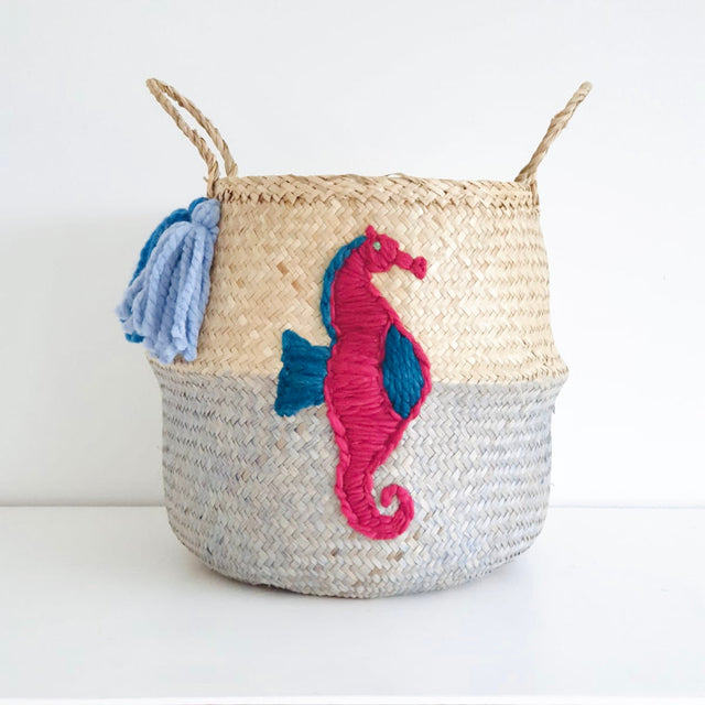 Woven basket with embroidered seahorse design on a white background