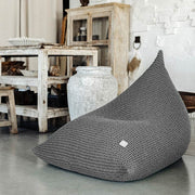 Grey bean bag chair in a room with white walls and wooden furniture.