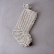 Knitted Christmas stocking with a red nose and antlers on a grey background