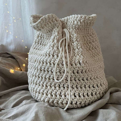Crochet Christmas present sack on a soft surface with a neutral background
