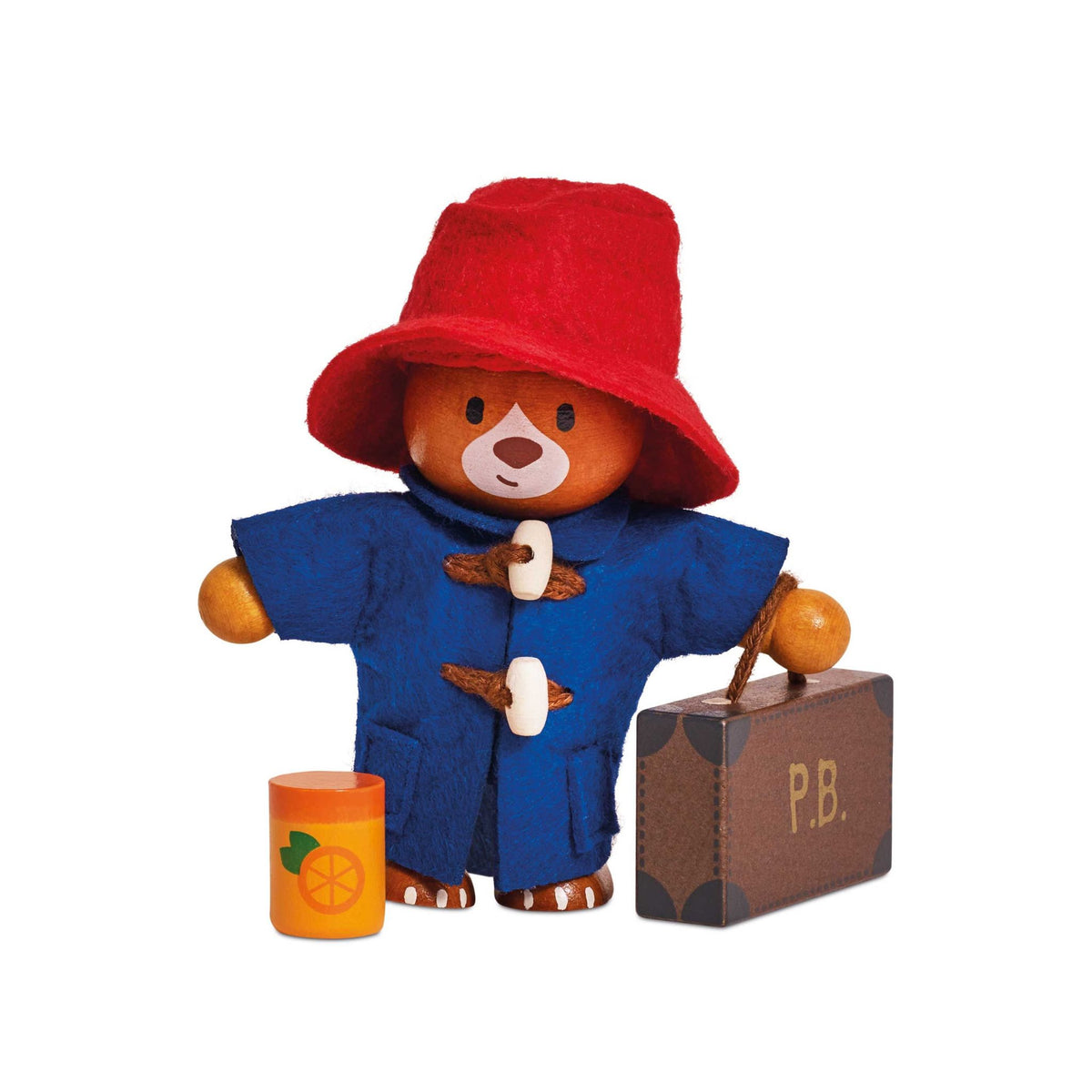 A wooden Paddington Bear toy figure wearing a red hat and blue duffle coat, standing beside a brown suitcase marked 'P.B.