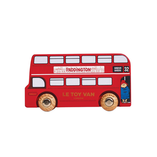 A red wooden double-decker toy bus with gold wheels, featuring Paddington-themed details including the word 'PADDINGTON' on the side and a small Paddington character illustration.