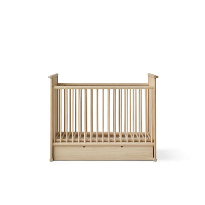 A light natural wood baby crib with vertical slats and a built-in storage drawer at the bottom, shown against a plain white background.