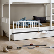 White Nordic day bed with trundle drawer, safety rail and wooden slats for kids' bedroom or guest room by Oliver Furniture Seaside Collection.