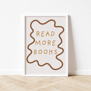 Framed poster with 'Read More Books' text on a white wall.