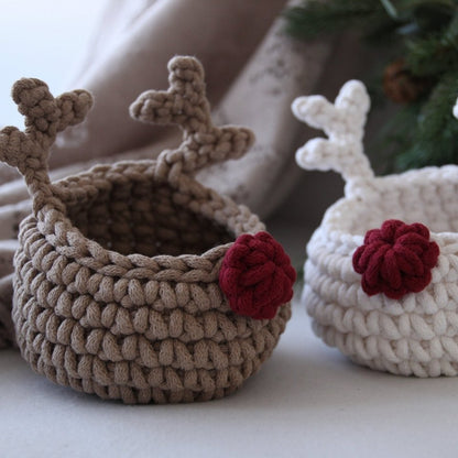 Two crocheted baskets with reindeer antlers and red noses on a neutral background