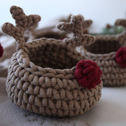Two crocheted reindeer-shaped baskets with red noses on a light background.