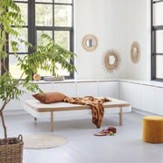 Oliver Furniture Wood Lounger in white and oak finish showcasing a comfortable Scandinavian design bed frame doubling as a daybed in a light-filled room. 