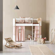 Stylish Oliver Furniture Wood Mini+ cabin curtains in soft pink cotton, creating a cozy den under a low loft bed. 