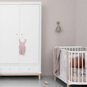 Oliver Furniture Wood Double Wardrobe in white and natural oak with soft-close drawers and flexible shelving, styled in a modern Scandinavian nursery beside a crib.