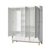 White and oak triple wardrobe with three doors, nine adjustable shelves, continuous hanging rail, soft-close drawers, and integrated oak hooks for Nordic-style bedroom and nursery storage.